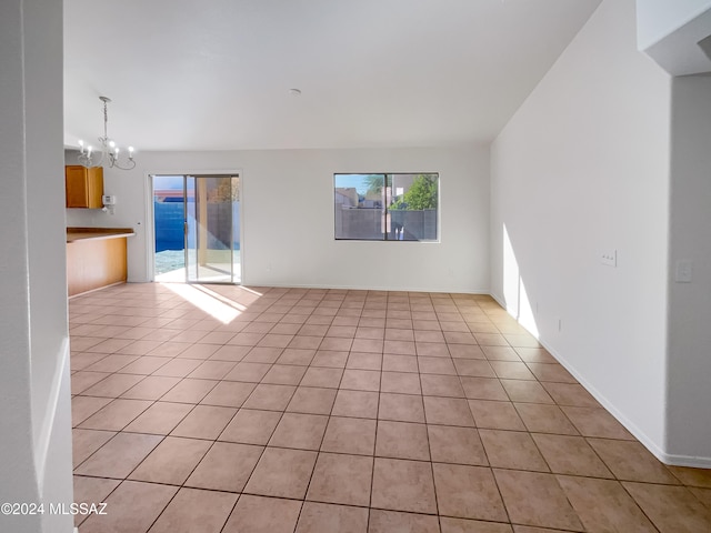 unfurnished living room featuring a chandelier and light tile patterned floors