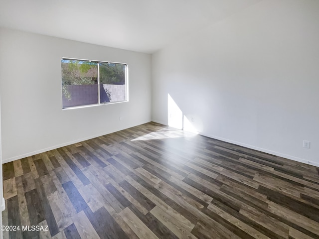 spare room featuring dark wood-type flooring