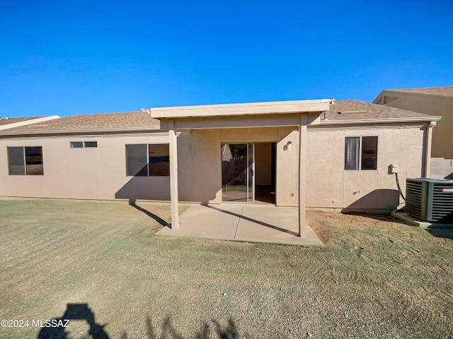 rear view of property with cooling unit, a yard, and a patio area