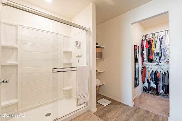 bathroom with wood-type flooring and an enclosed shower