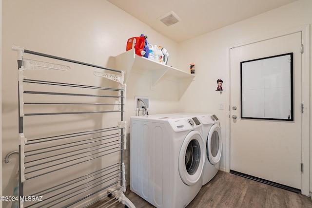 laundry area with radiator heating unit, independent washer and dryer, and dark wood-type flooring