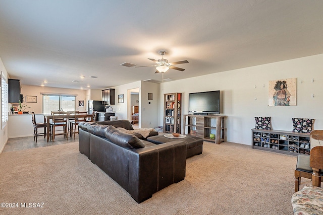 carpeted living room with ceiling fan