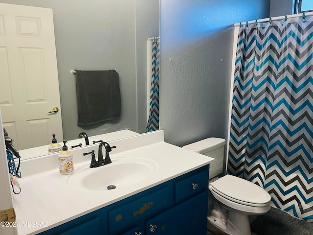 bathroom with toilet, vanity, and a shower with shower curtain