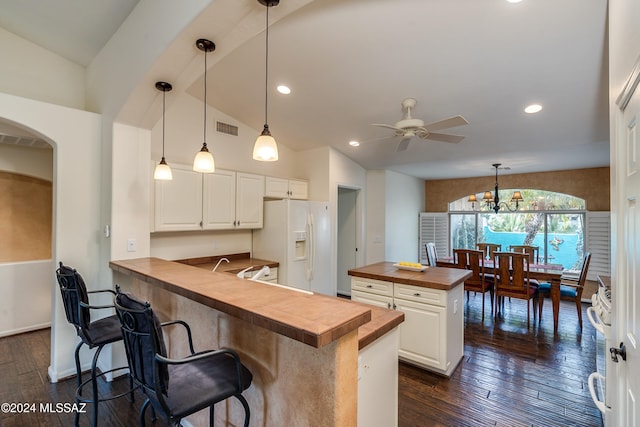 kitchen with a breakfast bar, wood counters, hanging light fixtures, kitchen peninsula, and white appliances