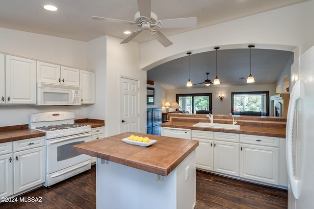 kitchen featuring white appliances, a center island, and white cabinets