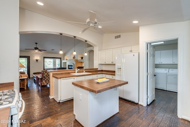 kitchen featuring pendant lighting, white cabinets, kitchen peninsula, washing machine and dryer, and white appliances