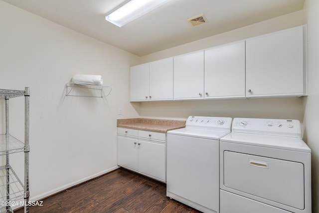 washroom with washer and dryer, dark hardwood / wood-style floors, and cabinets