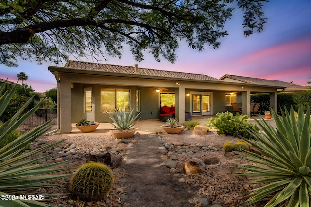 back house at dusk with a patio