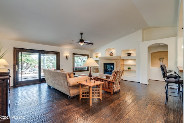 living room with vaulted ceiling, ceiling fan, dark hardwood / wood-style flooring, and built in shelves