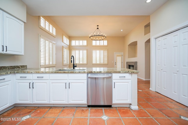 kitchen with dishwasher, light stone counters, a sink, and a notable chandelier