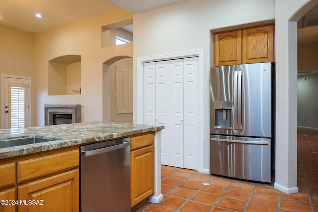 kitchen with light stone counters, light tile patterned floors, and appliances with stainless steel finishes