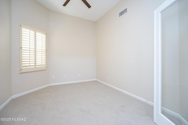 spare room featuring carpet, visible vents, vaulted ceiling, ceiling fan, and baseboards