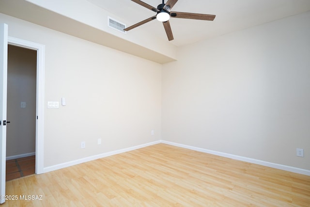 unfurnished room featuring wood finished floors, visible vents, and baseboards