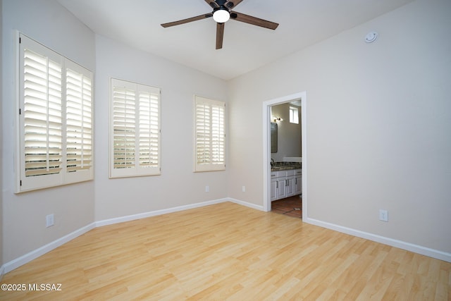 unfurnished room featuring a ceiling fan, baseboards, and wood finished floors