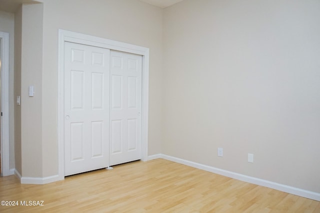 unfurnished bedroom featuring a closet and light hardwood / wood-style floors