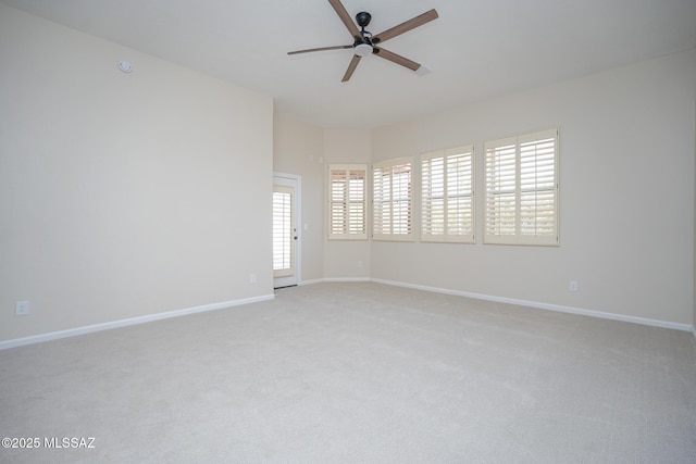 unfurnished room featuring a ceiling fan, light colored carpet, and baseboards