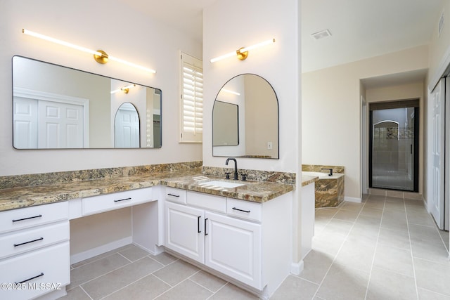 bathroom with visible vents, vanity, a bath, and tile patterned floors