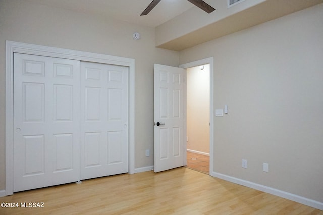 unfurnished bedroom featuring a closet, light hardwood / wood-style floors, and ceiling fan