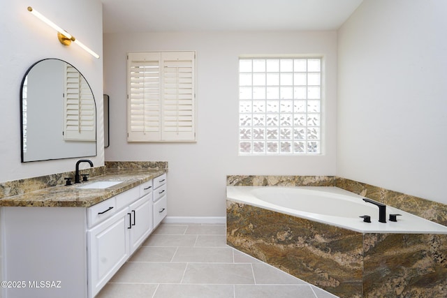 bathroom with a bath, vanity, and tile patterned floors