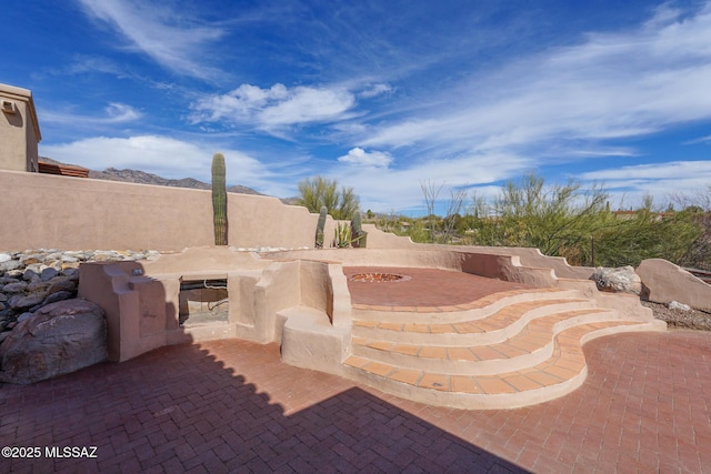 view of patio / terrace featuring an outdoor fire pit and fence