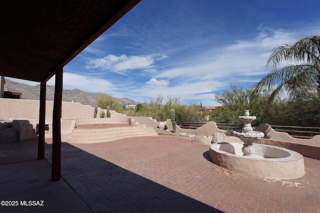 view of patio / terrace with a mountain view and fence