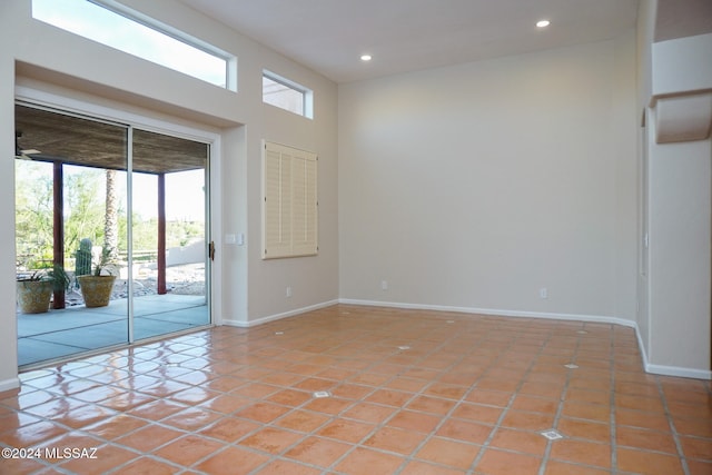 tiled empty room with plenty of natural light and a high ceiling