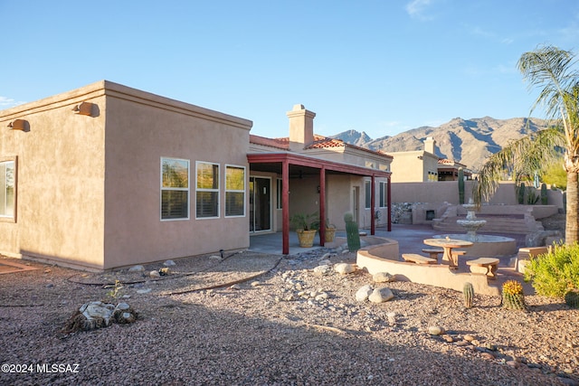 rear view of property with a mountain view and a patio