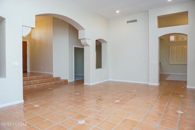 tiled empty room with a high ceiling