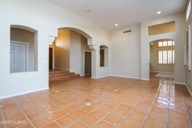 unfurnished room with light tile patterned floors, a high ceiling, visible vents, and recessed lighting