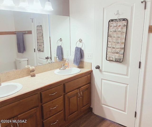 bathroom featuring vanity, hardwood / wood-style flooring, and toilet