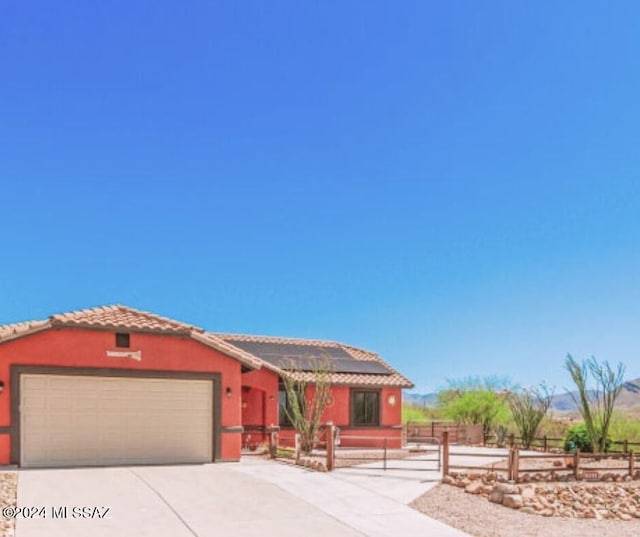 view of front of house featuring solar panels and a garage