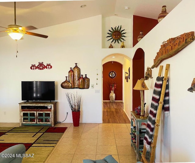 tiled living room featuring ceiling fan and high vaulted ceiling