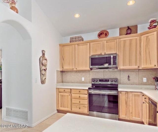 kitchen featuring tasteful backsplash, light brown cabinets, light tile patterned floors, and stainless steel appliances