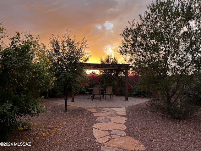 patio terrace at dusk featuring a pergola