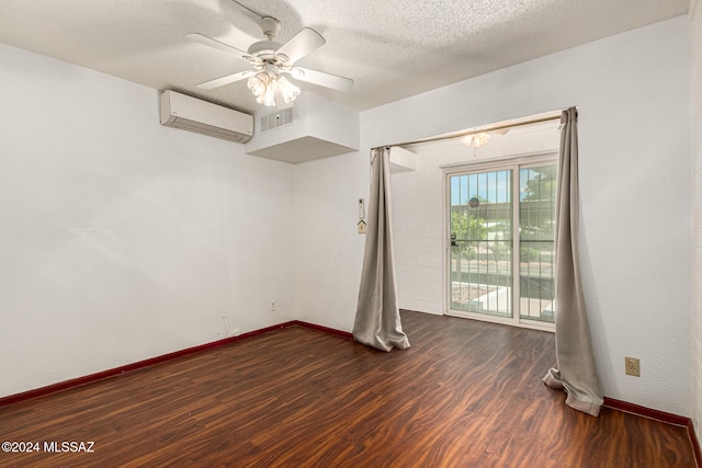 unfurnished room featuring ceiling fan, a wall mounted AC, dark hardwood / wood-style floors, and a textured ceiling