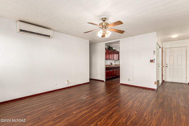 unfurnished living room featuring a textured ceiling, a wall mounted air conditioner, and dark hardwood / wood-style floors