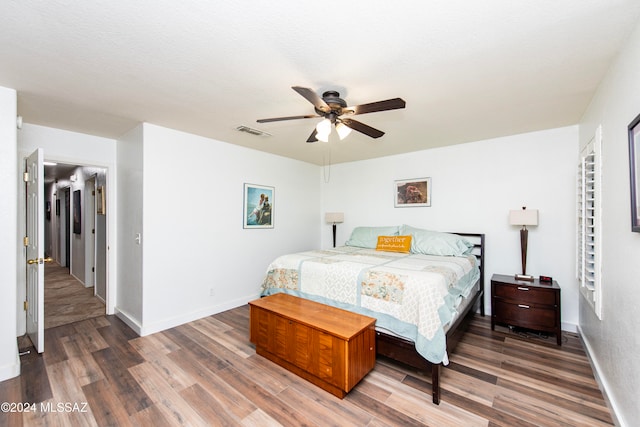 bedroom featuring ceiling fan, dark hardwood / wood-style flooring, and a textured ceiling