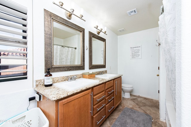 bathroom featuring tile patterned flooring, vanity, curtained shower, and toilet