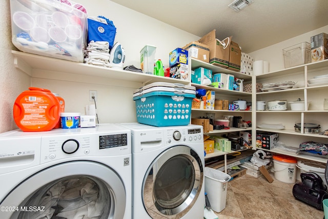 clothes washing area with separate washer and dryer and a textured ceiling