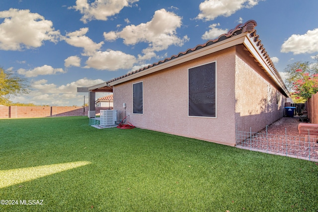 back of property with a lawn and central AC unit