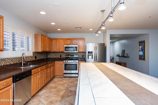 kitchen featuring appliances with stainless steel finishes, tasteful backsplash, hanging light fixtures, and sink