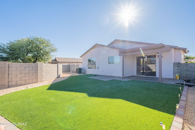 back of house featuring a lawn, cooling unit, and a patio