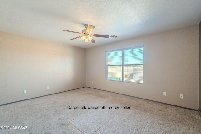 carpeted spare room featuring a textured ceiling and ceiling fan