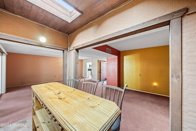 dining area featuring a skylight and carpet flooring