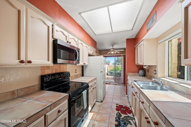 kitchen with tile counters, sink, light tile patterned floors, backsplash, and electric range