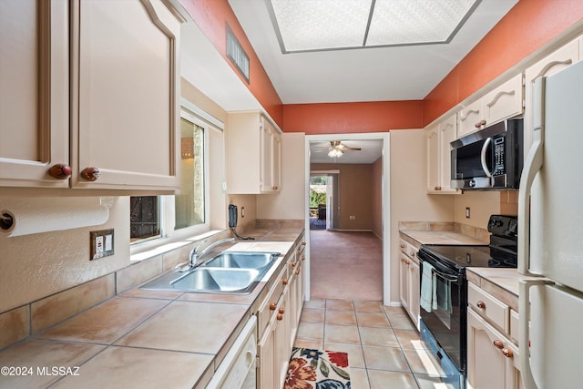 kitchen with tile countertops, white appliances, sink, and light carpet