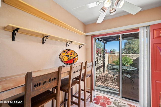 tiled dining space with ceiling fan