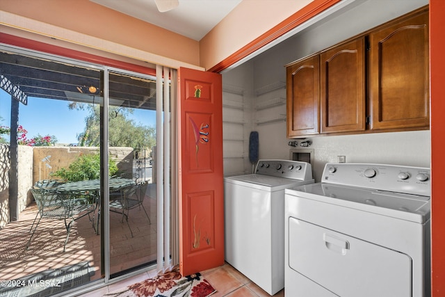 laundry room featuring washer and clothes dryer, cabinets, and light tile patterned flooring