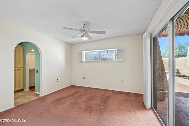 spare room with light colored carpet, a textured ceiling, and ceiling fan