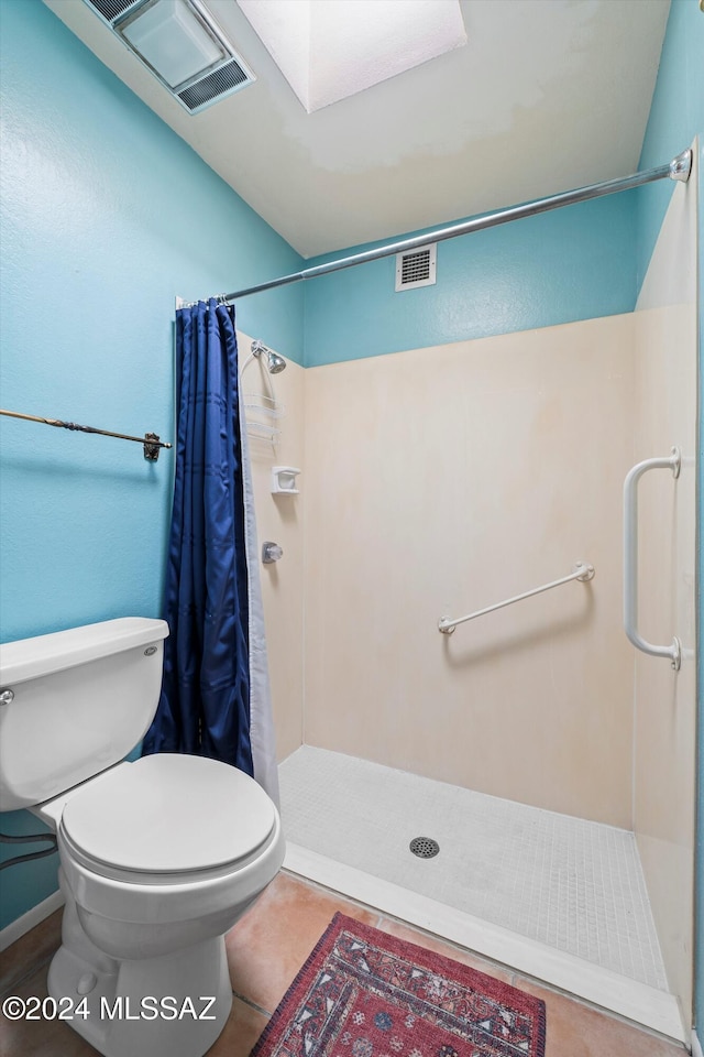 bathroom with tile patterned flooring, toilet, and a shower with curtain